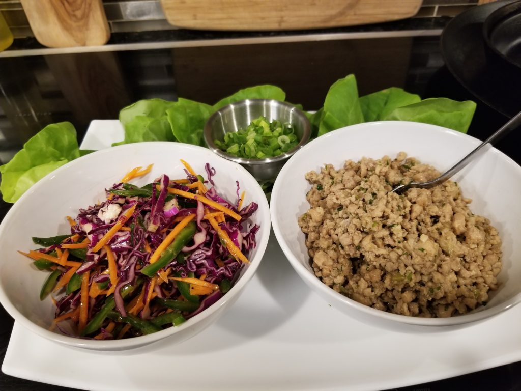 bowls of seasoned chicken and a julienne blend of colorful vegetables