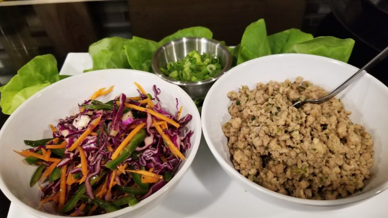 bowls of seasoned chicken and a julienne blend of colorful vegetables